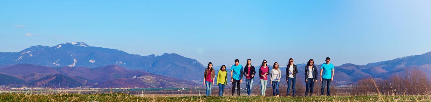 kids standing in a line with mountains in the background