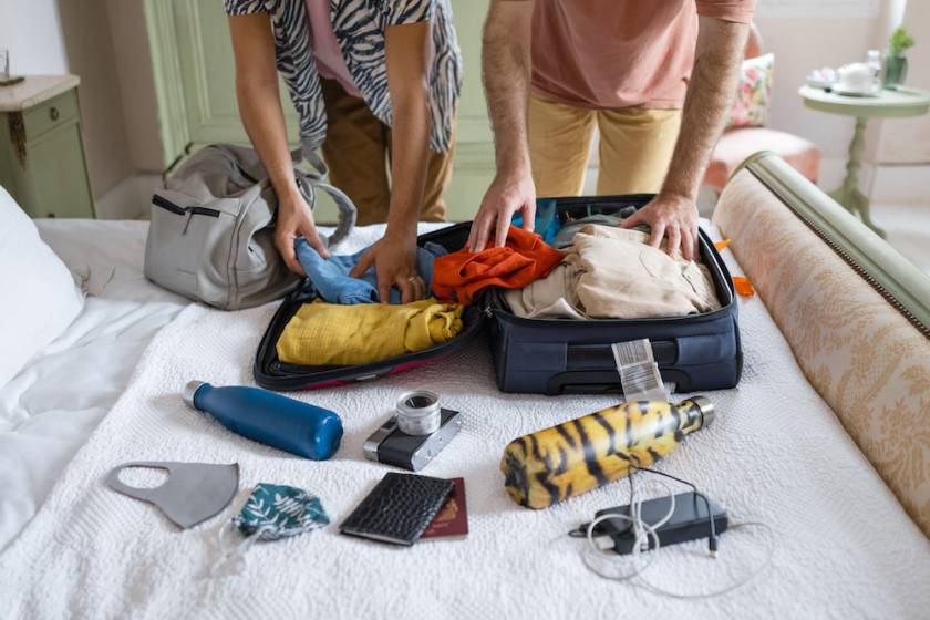 two people packing a suitcase