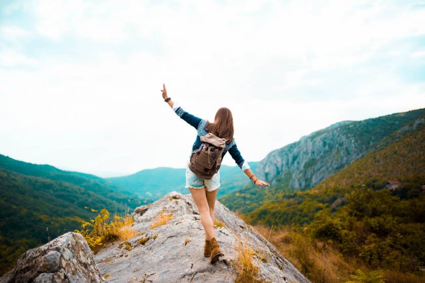 Young girl taking a walk on top of a mountain and enjoying the day. rear view