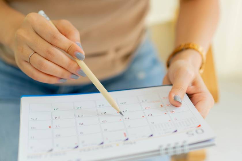 close up of woman holding a calendar, with focus on the calendar